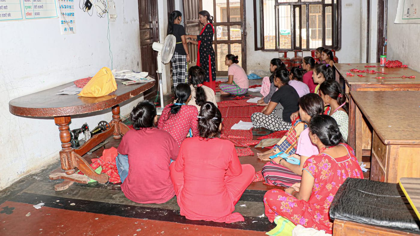 Four women holding sheets of paper